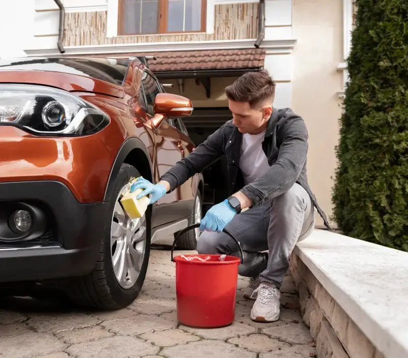 Lavage auto à domicile Ouilly-le-Vicomte : professionnel intervenant sur un véhicule